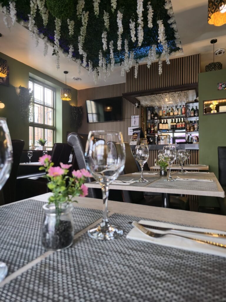 Dining room at Yannis & Daddy with set tables, flower ceiling and bar
