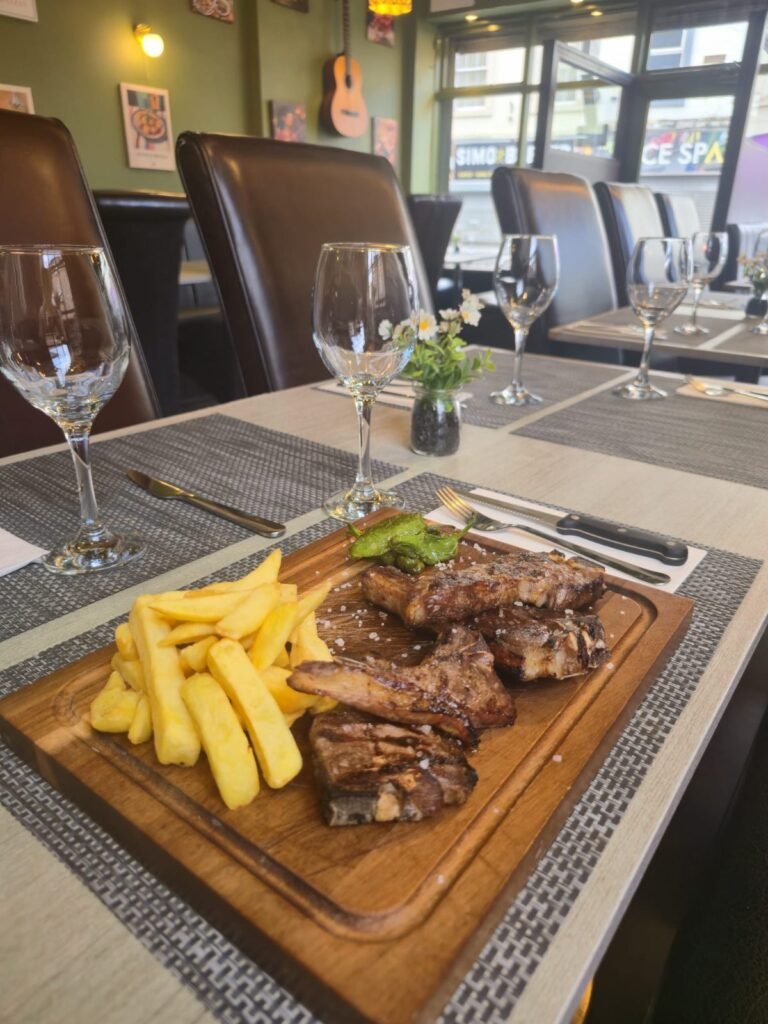 Grilled lamb chops with chips on a wooden board