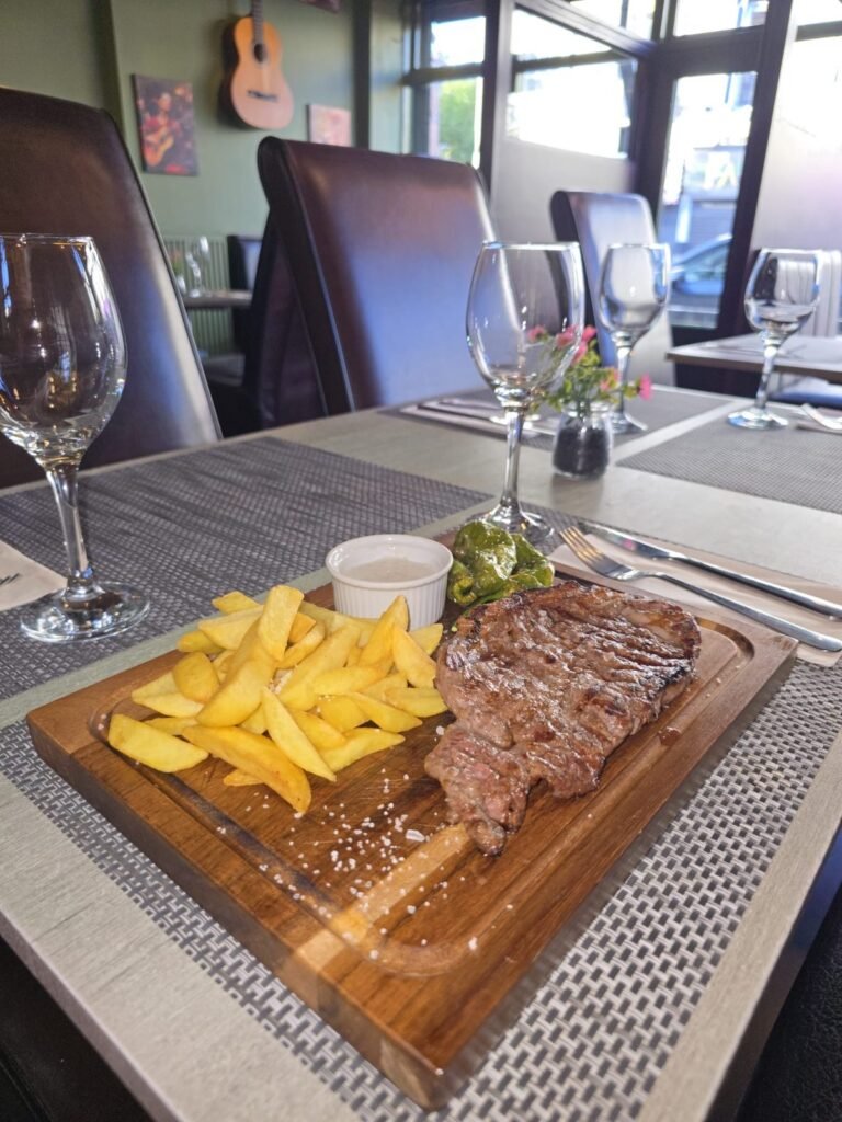Grilled sirloin steak with chips on a wooden board